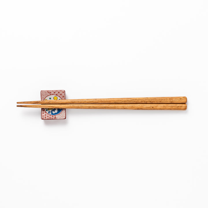 Rectangular Japanese ceramic chopstick rest with red geometric pattern and moon rabbit motif, blending playful design and tradition for a charming table accent.