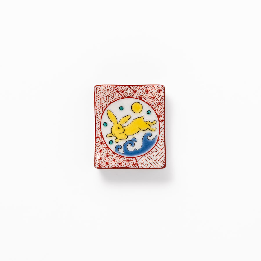 Rectangular Japanese ceramic chopstick rest with red geometric pattern and moon rabbit motif, blending playful design and tradition for a charming table accent.