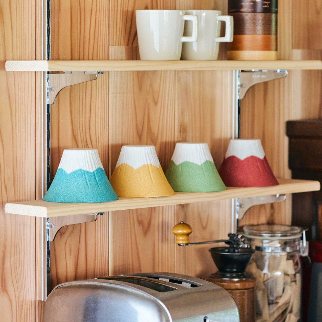 Colorful Mount Fuji shaped ceramic coffee filters handcrafted in Japan, beautifully displayed on wooden kitchen shelves.