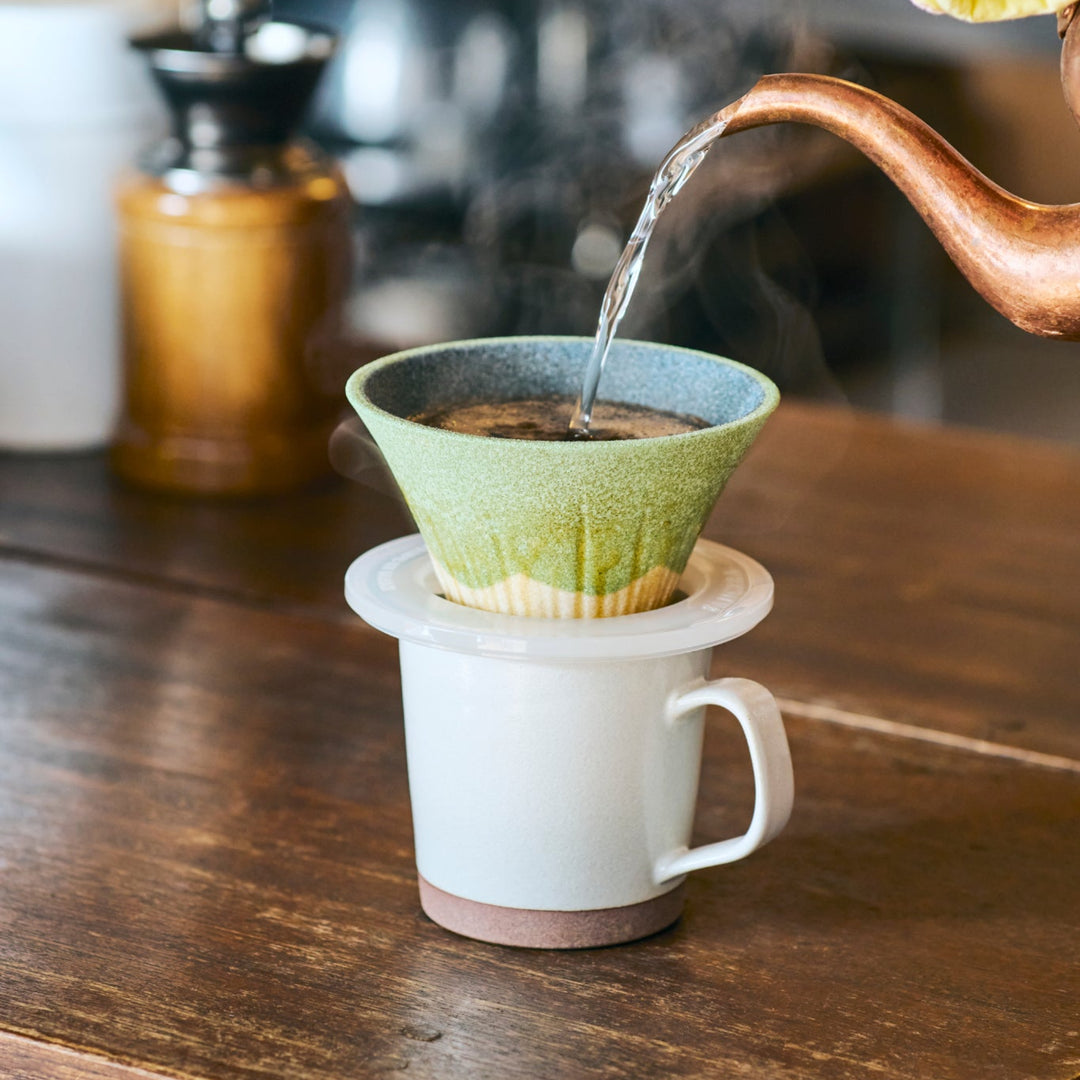 Handcrafted Mount Fuji shaped ceramic coffee filter in wasabi green glaze, brewing aromatic pour over coffee with Japanese elegance.