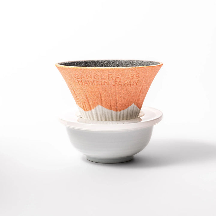 Orange Mount Fuji ceramic coffee filter with snowy peak design, handcrafted in Japan for reusable pour-over brewing and modern kitchen decor.