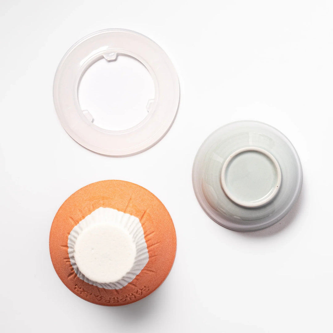 Orange Mount Fuji ceramic coffee filter with snowy peak design, handcrafted in Japan for reusable pour-over brewing and modern kitchen decor.