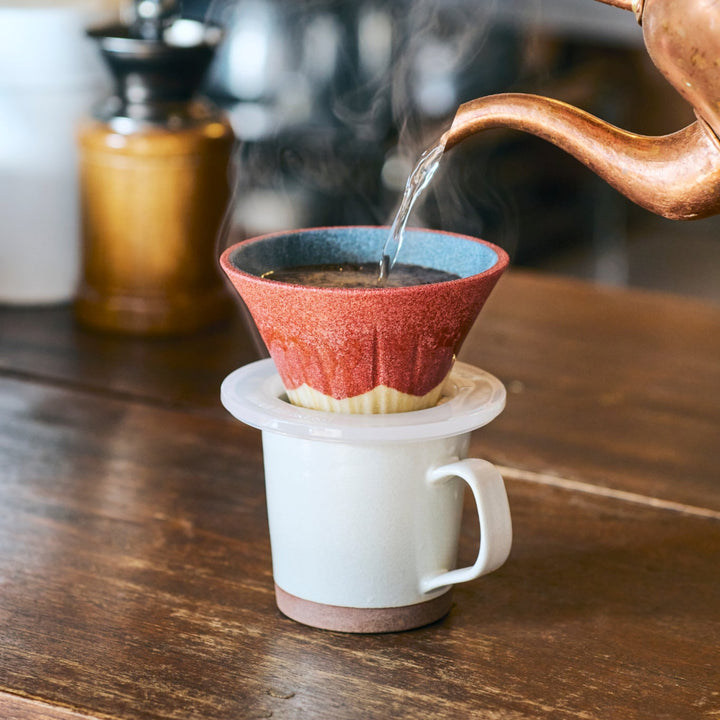 Red Mount Fuji inspired ceramic coffee filter handcrafted in Japan, brewing rich pour over coffee with gentle rising steam.