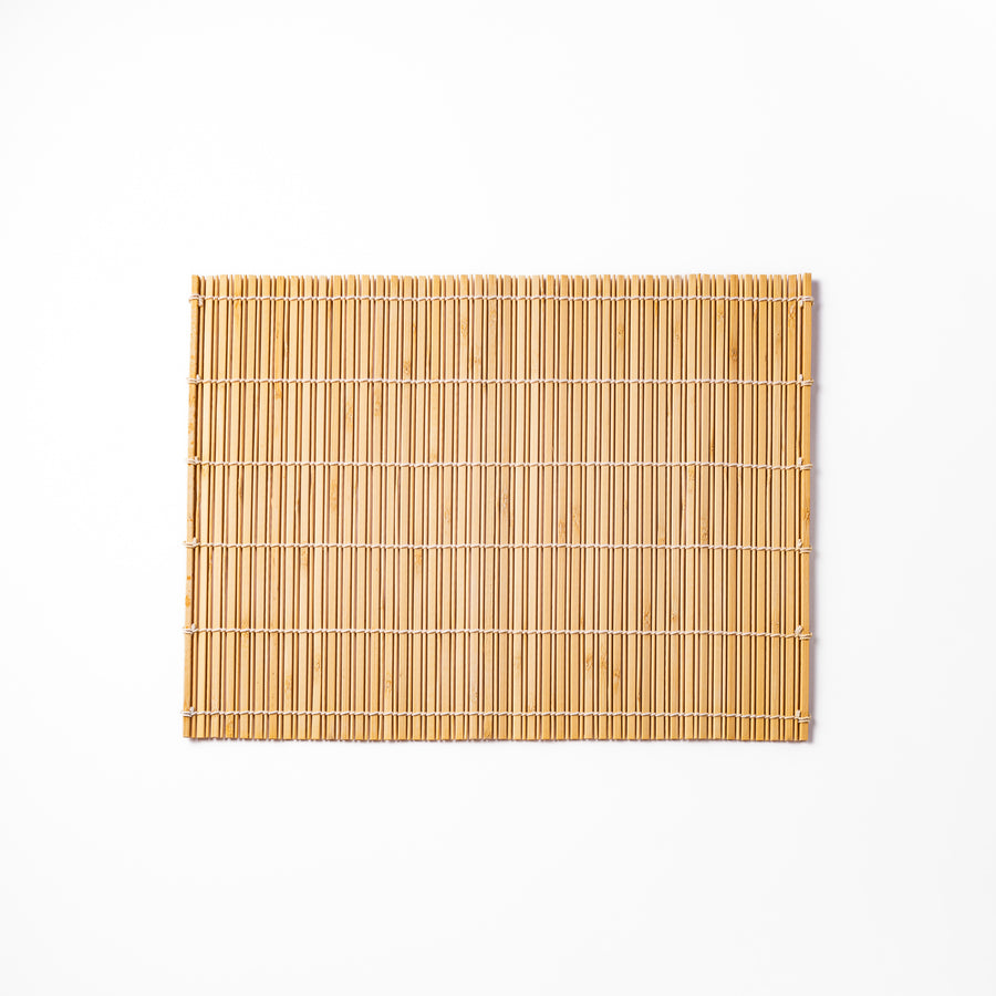 Natural finish bamboo table mat with slim vertical slats and white cord binding, offering a clean, earthy touch to traditional Japanese table settings.