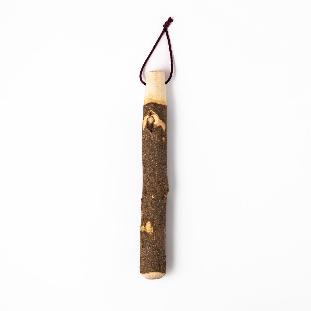 Natural sansho wood pestle featuring bark textures and a burgundy hanging cord, ideal for traditional Japanese grinding.