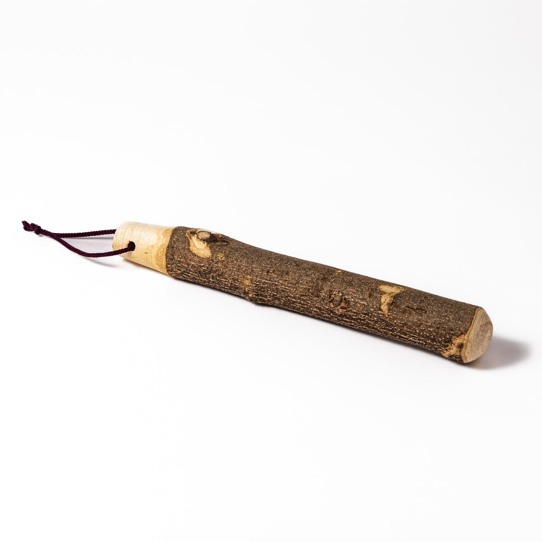 Natural sansho wood pestle featuring bark textures and a burgundy hanging cord, ideal for traditional Japanese grinding.