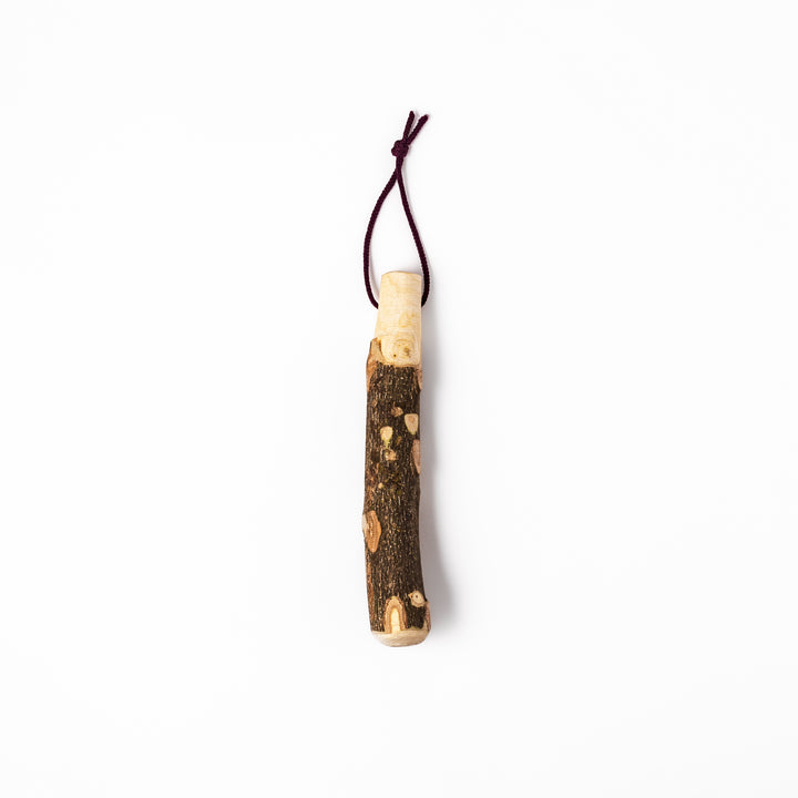 Natural sansho wood pestle featuring bark textures and a burgundy hanging cord, ideal for traditional Japanese grinding.
