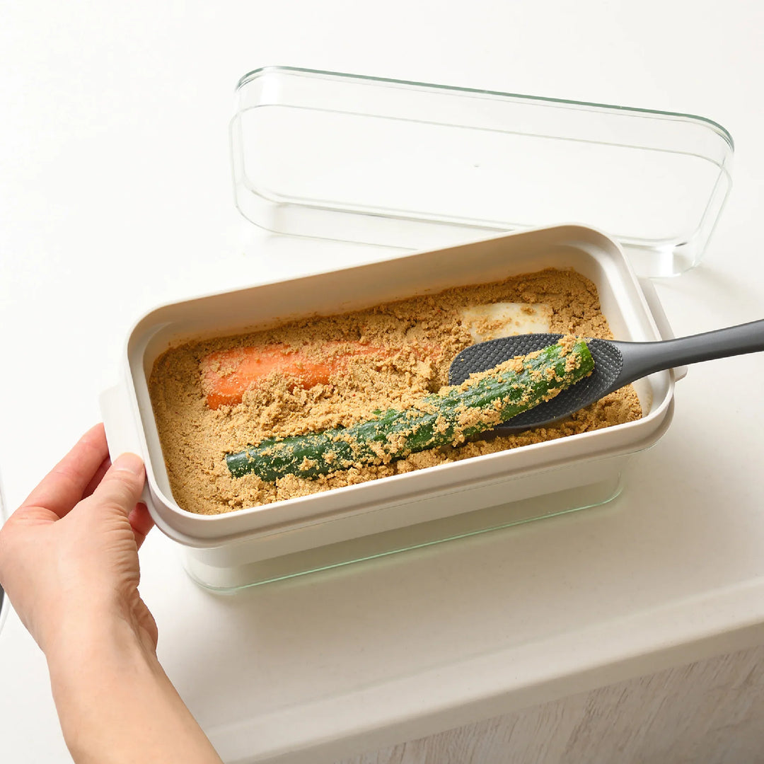 Japanese nukadoko fermentation box with rice bran bed, shown pickling cucumber and carrot, ideal for homemade tsukemono.