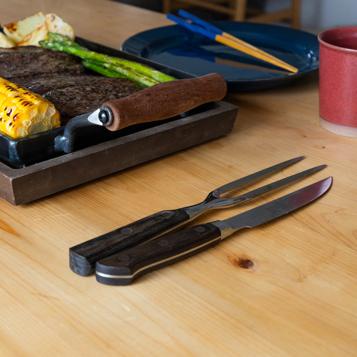 Japanese carving knife and fork set on wooden table with steak griddle plate barbecue kitchen cutlery tableware