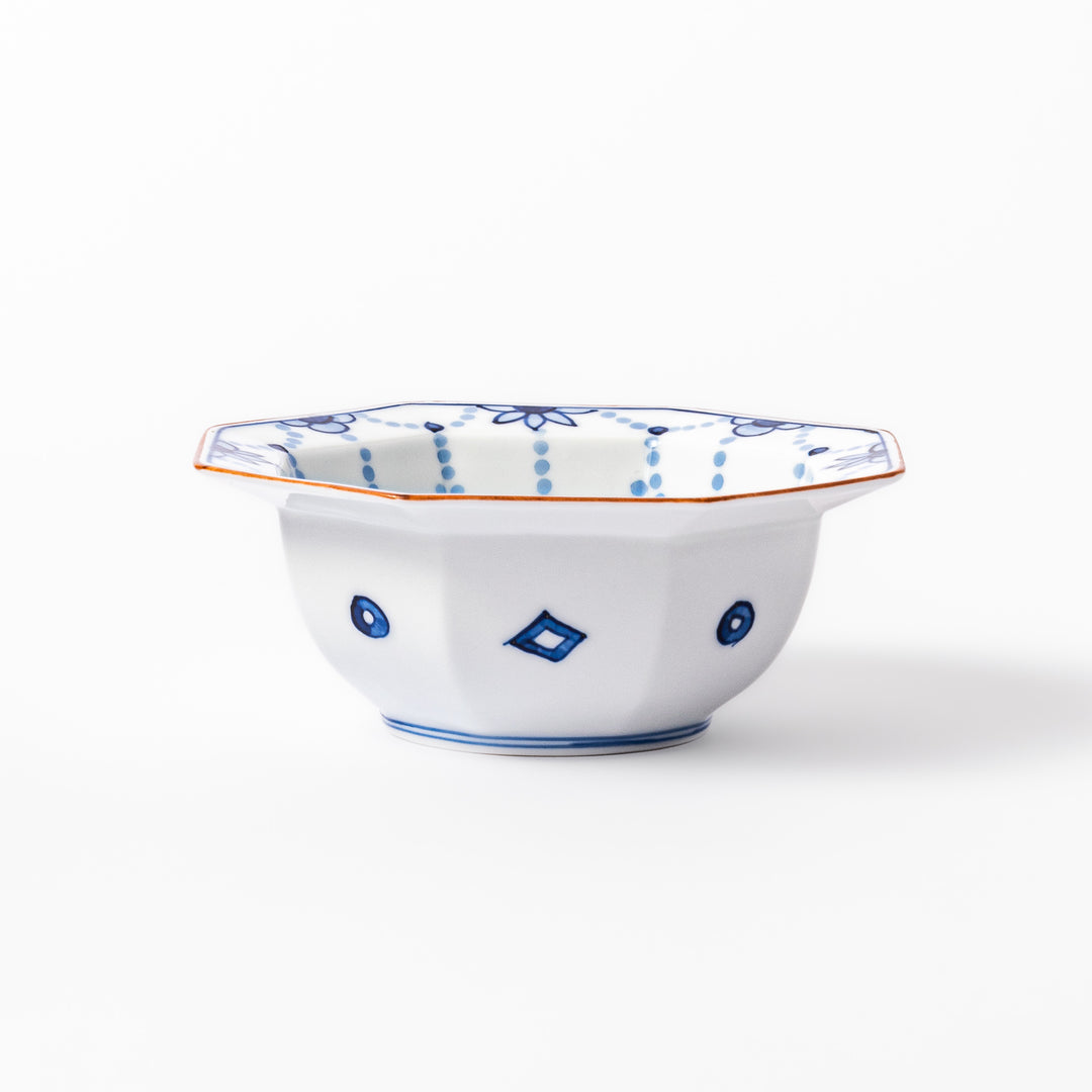 White octagonal dessert bowl with blue floral garland patterns and a red-rimmed edge, featuring intricate geometric detailing.