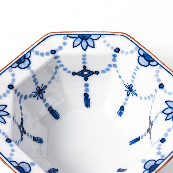 White octagonal dessert bowl with blue floral garland patterns and a red-rimmed edge, featuring intricate geometric detailing.