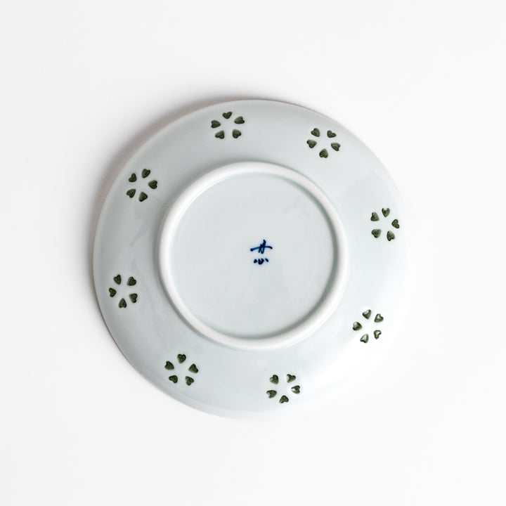 Delicate teacup and saucer set featuring intricate petal-shaped cutouts, allowing light to pass through, creating a soft, elegant design in pale green and white porcelain.