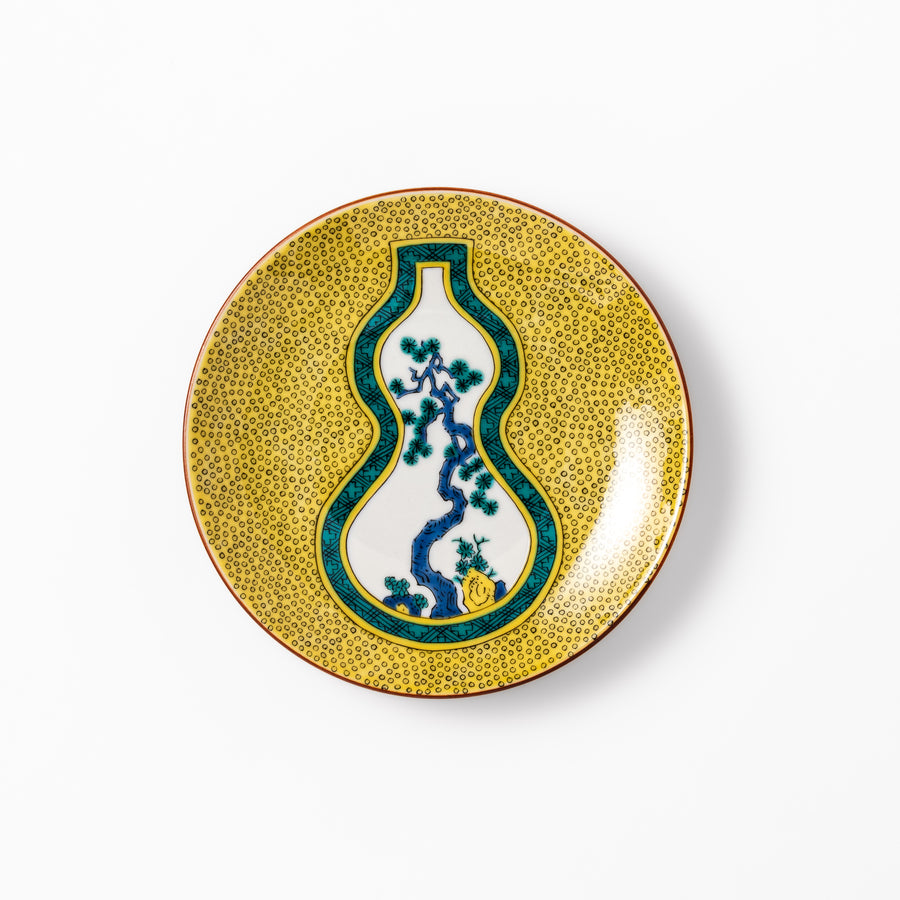 Japanese dessert plate featuring a yellow patterned background with a gourd-shaped center, showcasing a blue pine tree and green foliage.