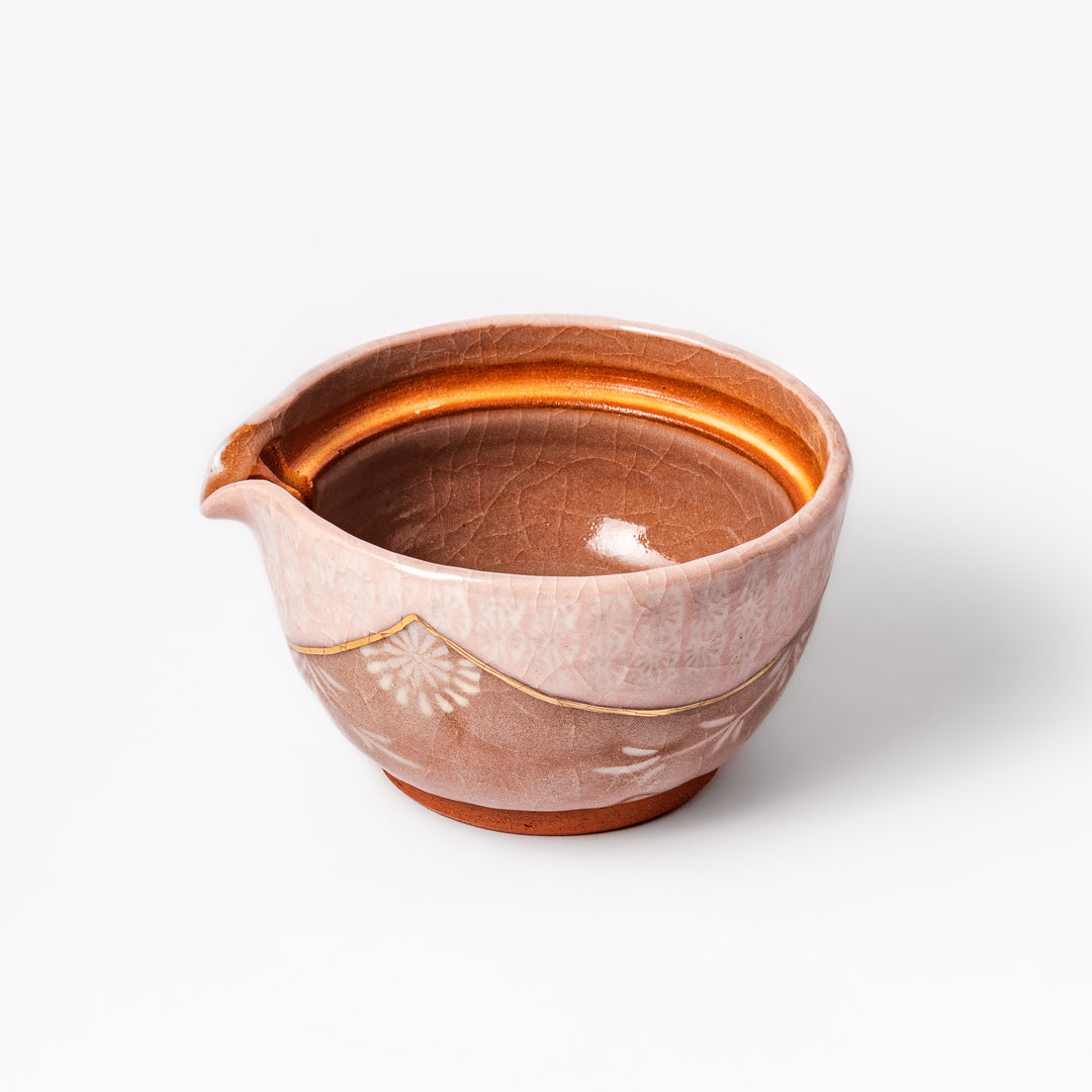 Ceramic teapot with a soft pink crackled glaze, floral patterns, and a curved spout accented by a hand-applied gold line for an artisanal touch.