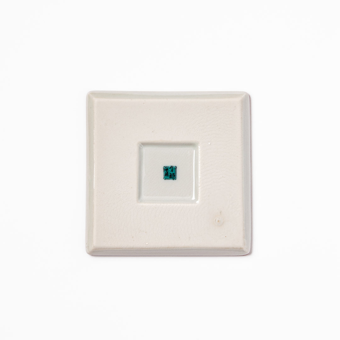 Square Japanese ceramic coaster with red and white checkered pattern decorated with plum blossom motifs, adding traditional charm to any dining table.