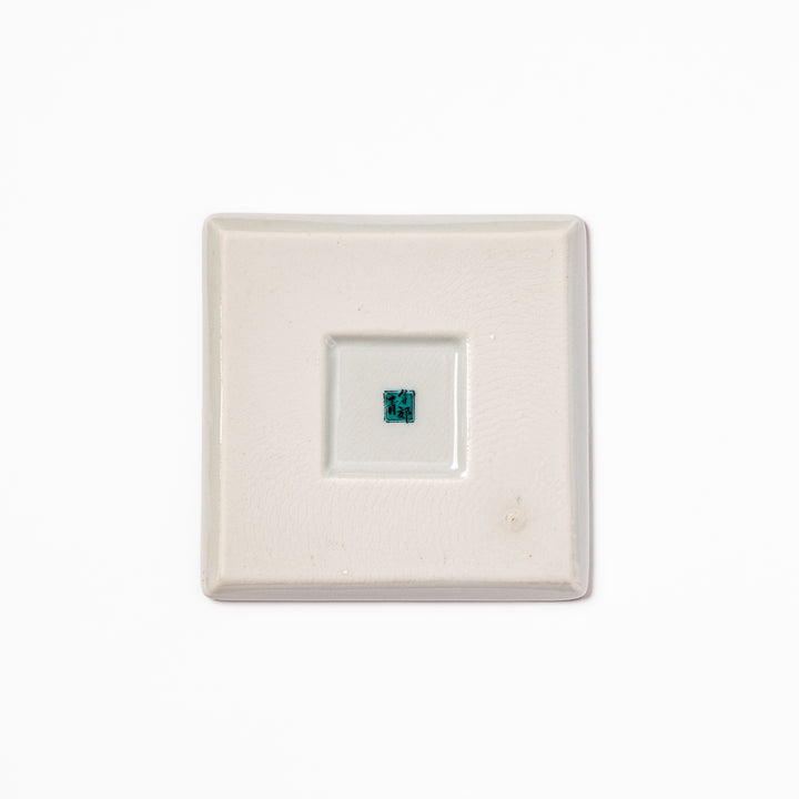 Square Japanese ceramic coaster with red and white checkered pattern decorated with plum blossom motifs, adding traditional charm to any dining table.