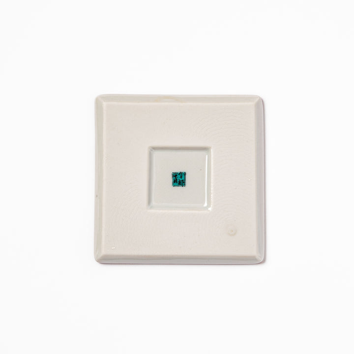 Square Japanese ceramic coaster with a red background decorated with colorful plum and chrysanthemum blossoms, adding elegance and tradition to table settings.