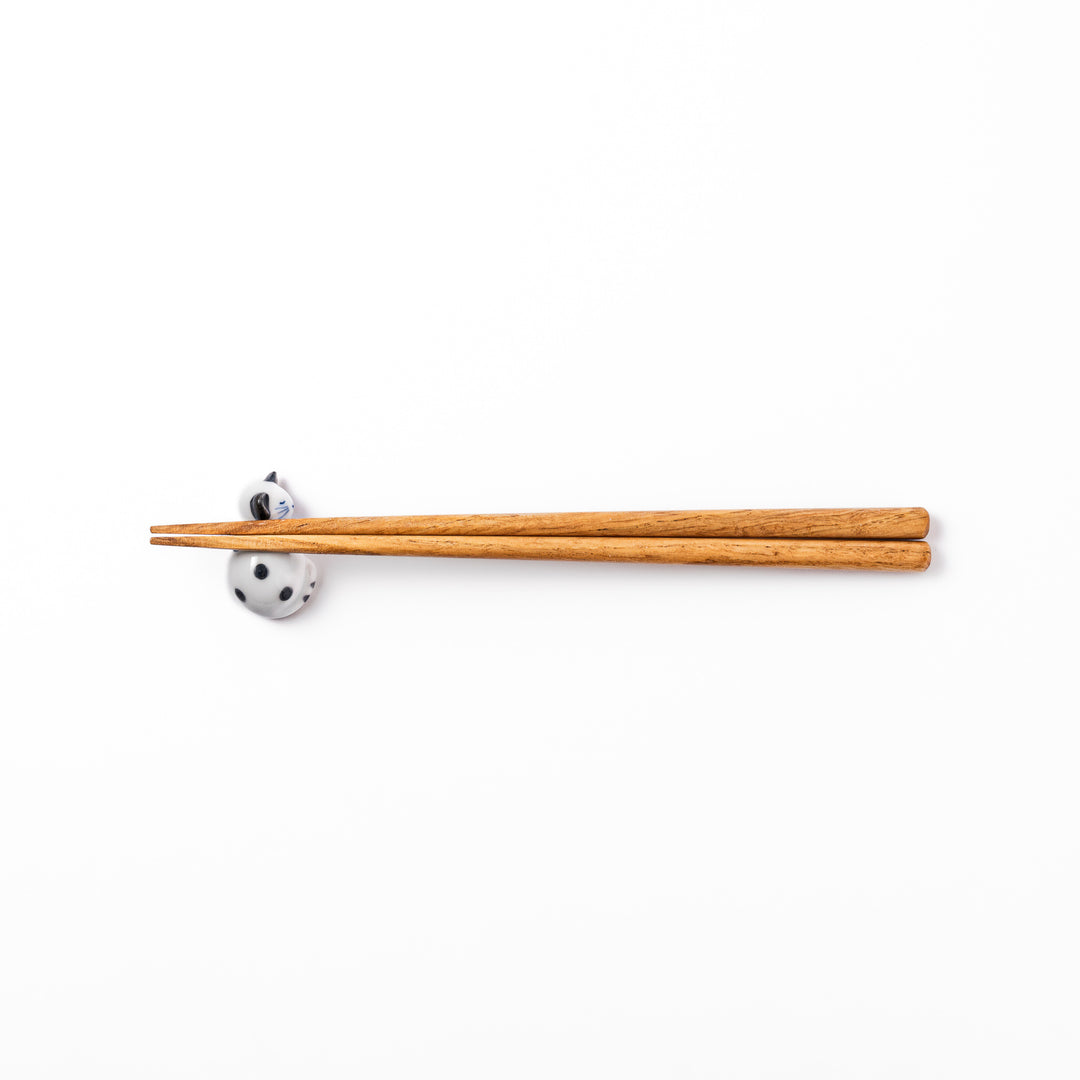 Black polka dot cat-shaped ceramic chopstick rest with a peaceful expression, perfect for adding a playful touch to your table.