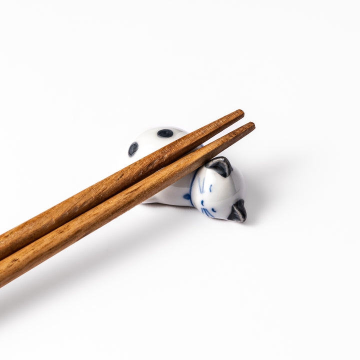 Black polka dot cat-shaped ceramic chopstick rest with a peaceful expression, perfect for adding a playful touch to your table.