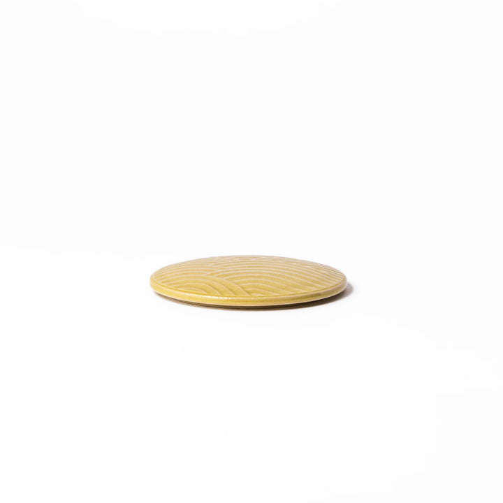 Yellow porcelain lid with embossed Seigaiha wave pattern, designed to fit stackable Japanese bowls with a modern touch.