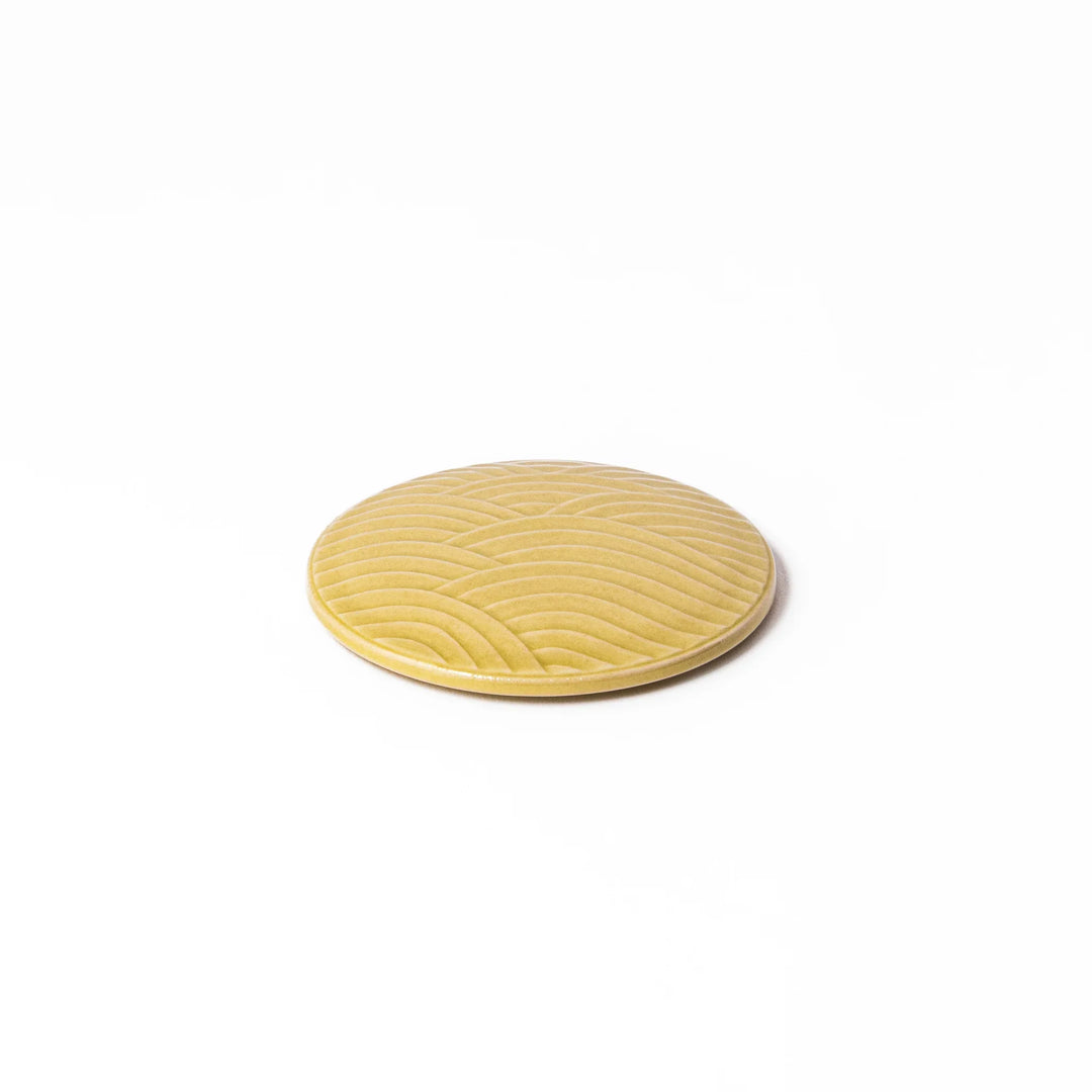 Yellow porcelain lid with embossed Seigaiha wave pattern, designed to fit stackable Japanese bowls with a modern touch.