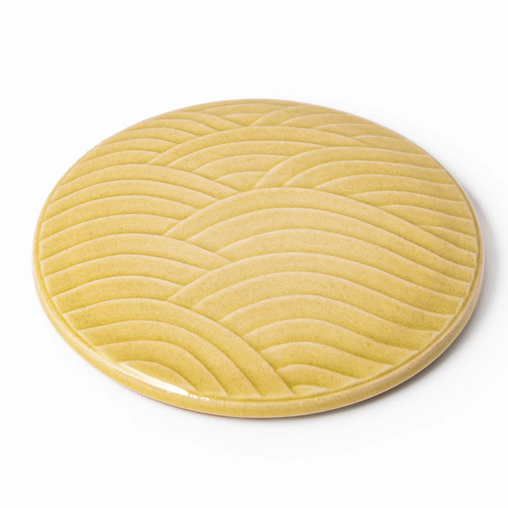 Yellow porcelain lid with embossed Seigaiha wave pattern, designed to fit stackable Japanese bowls with a modern touch.
