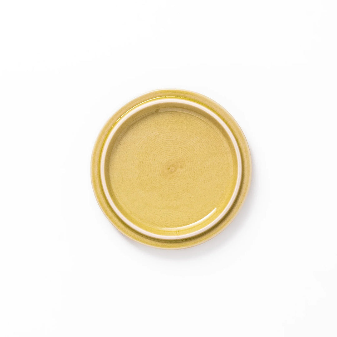 Yellow porcelain lid with embossed Seigaiha wave pattern, designed to fit stackable Japanese bowls with a modern touch.