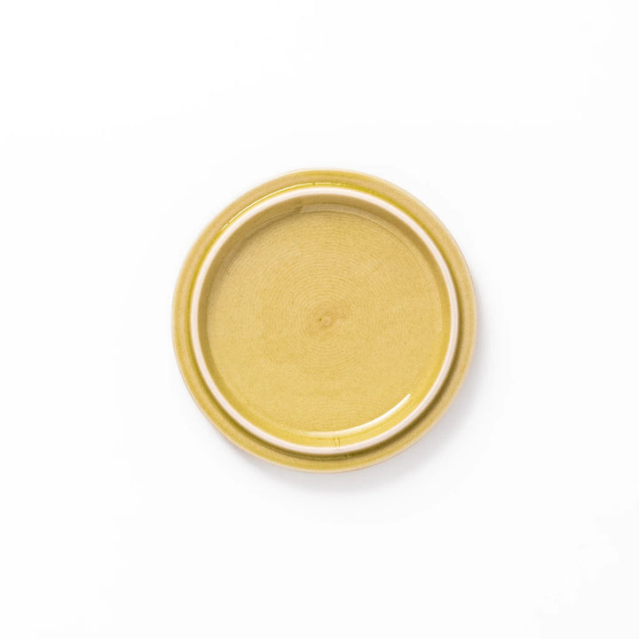 Yellow porcelain lid with embossed Seigaiha wave pattern, designed to fit stackable Japanese bowls with a modern touch.