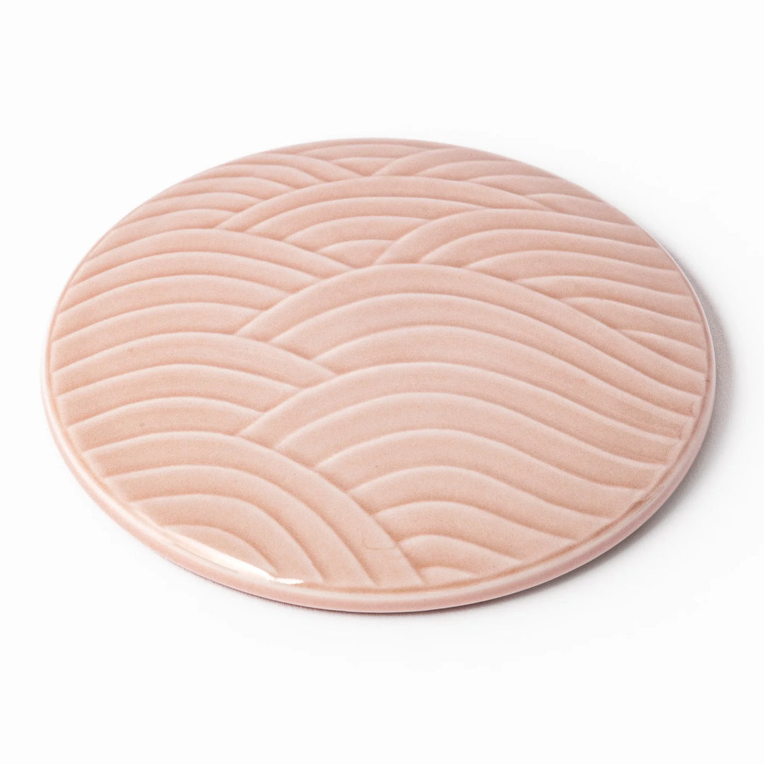Soft pink porcelain lid with embossed Seigaiha wave design, crafted to pair with stackable Japanese bowls for elegant dining.