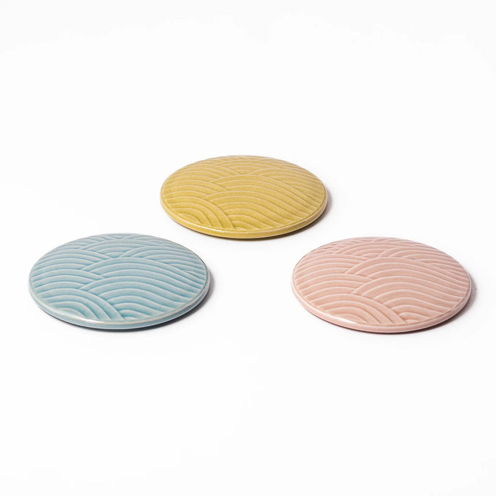 Three porcelain lids in pastel blue, yellow, and pink with embossed Seigaiha wave pattern for Japanese stackable bowls.