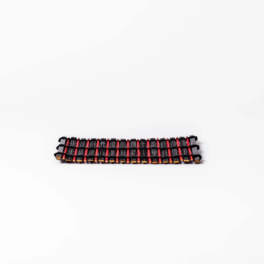 Red and black bamboo coaster with slim vertical slats and black cord ties, ideal for adding a striking accent to Japanese-style drink settings.