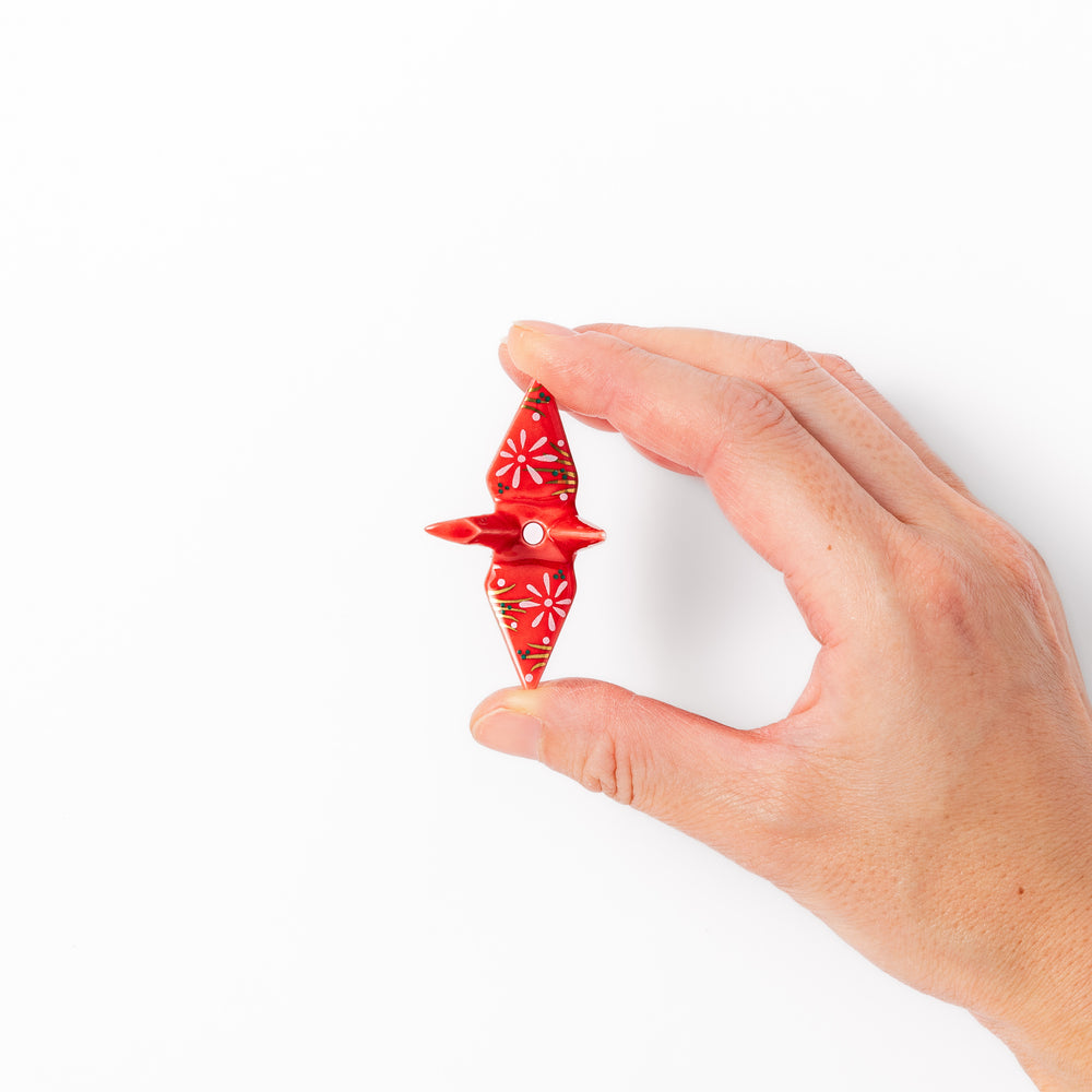 Red ceramic origami crane incense holder with delicate floral details, blending Japanese tradition and modern tableware design
