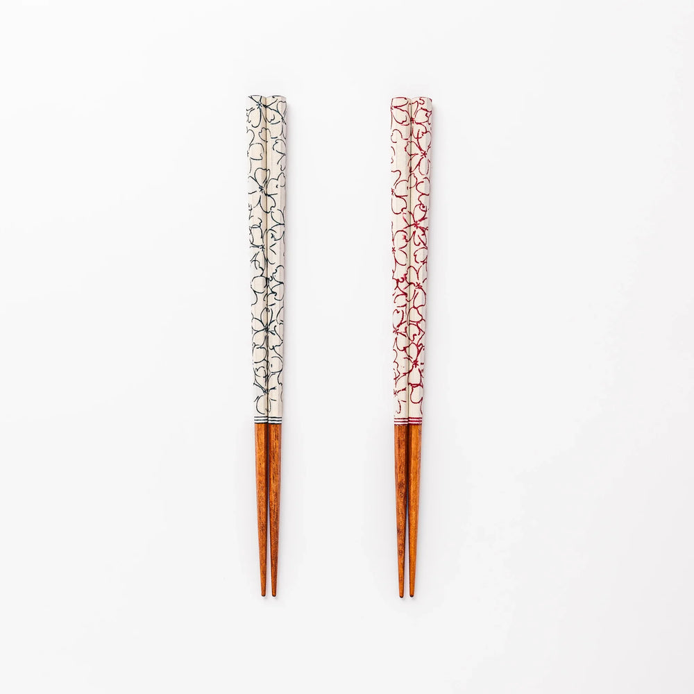 Red and blue Sakura Japanese chopsticks gift set with cherry blossom pattern handles in a wooden presentation box.
