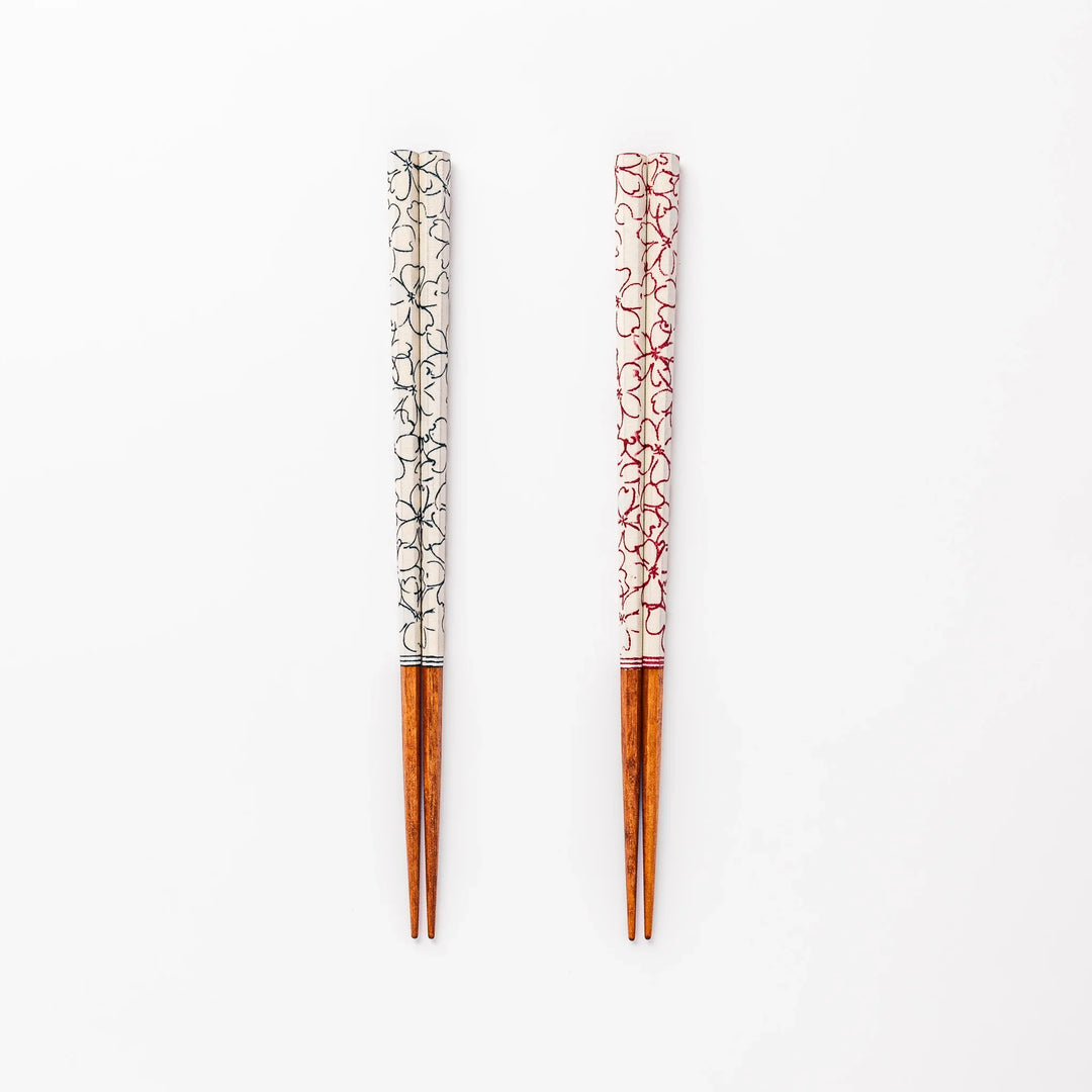 Red and blue Sakura Japanese chopsticks gift set with cherry blossom pattern handles in a wooden presentation box.
