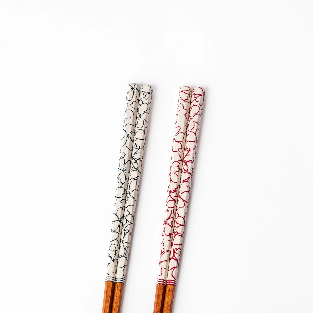 Red and blue Sakura Japanese chopsticks gift set with cherry blossom pattern handles in a wooden presentation box.