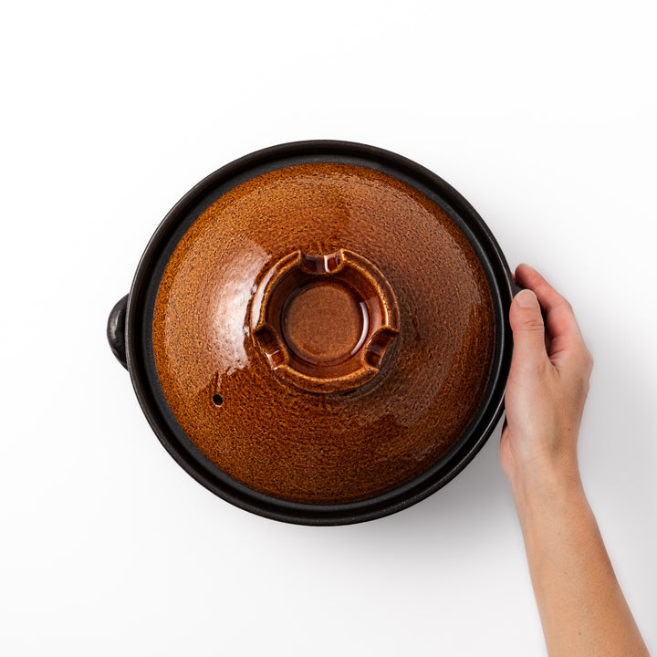 Japanese donabe clay pot with rustic brown glazed lid and black base, induction compatible and ideal for 2–3 person hot pot meals
