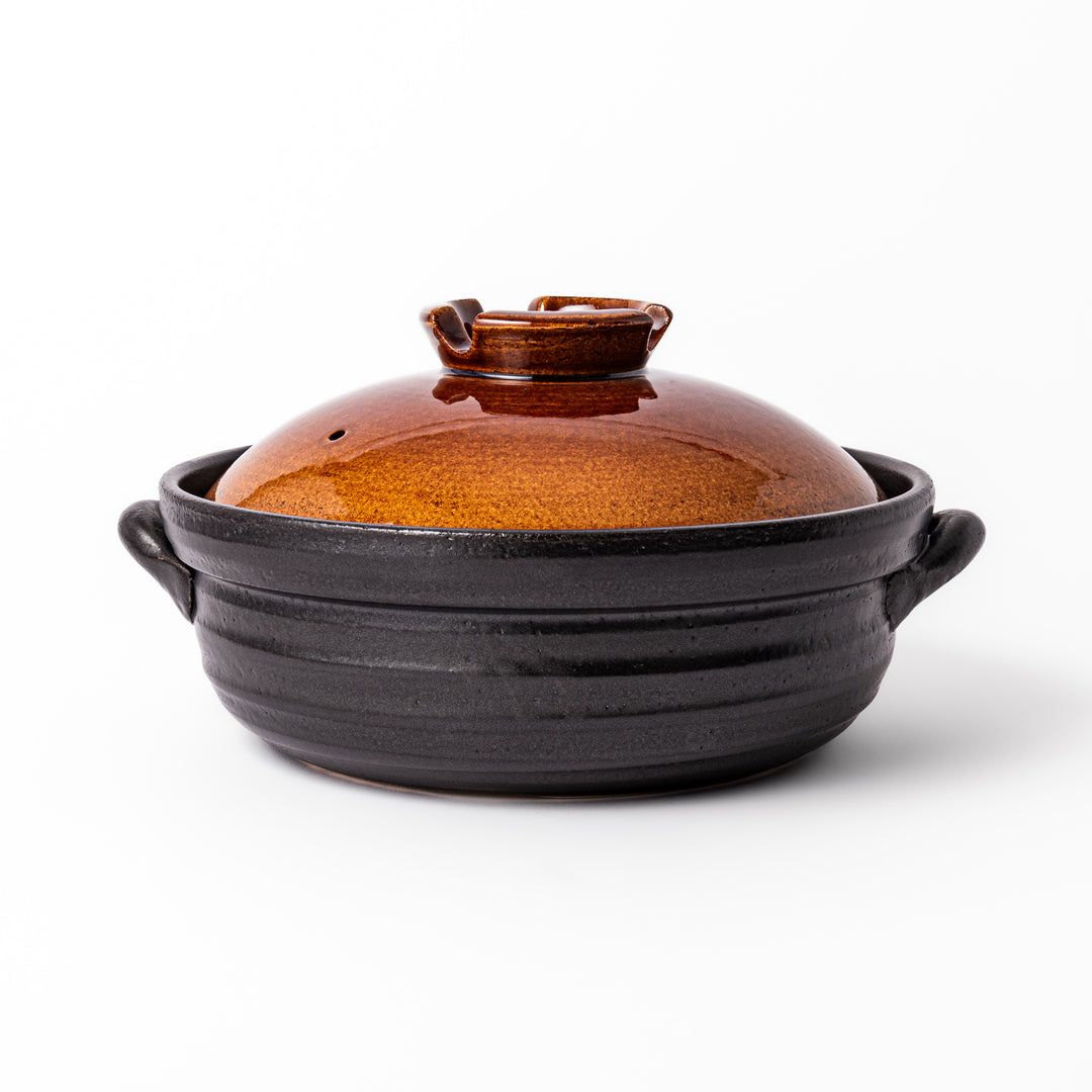 Japanese donabe clay pot with rustic brown glazed lid and black base, induction compatible and perfect for family hot pot meals.