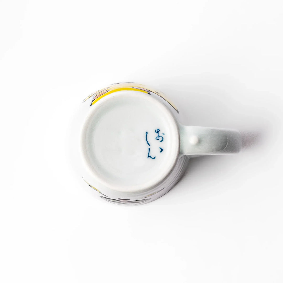 White ceramic kids mug featuring smiling yellow giraffe with green ossicones, vibrant yellow interior, round handle, shown on white background