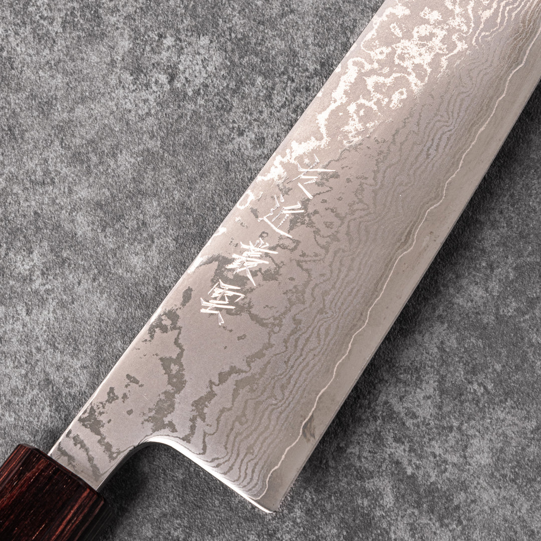 Japanese Damascus gyuto knife featuring a layered steel blade and natural wood handle displayed on gray stone background.