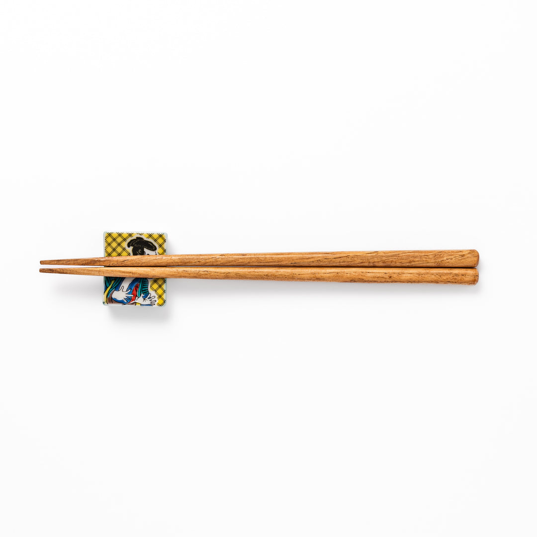 Rectangular Japanese ceramic chopstick rest featuring a bold kabuki actor design inspired by Sharaku’s ukiyo-e, adding dramatic artistry to dining tables.