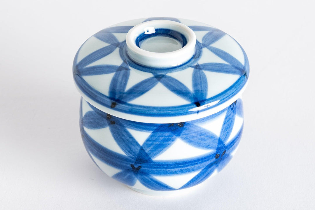 Blue porcelain chawanmushi bowl with hand painted basket weave pattern and fitted lid on a white background