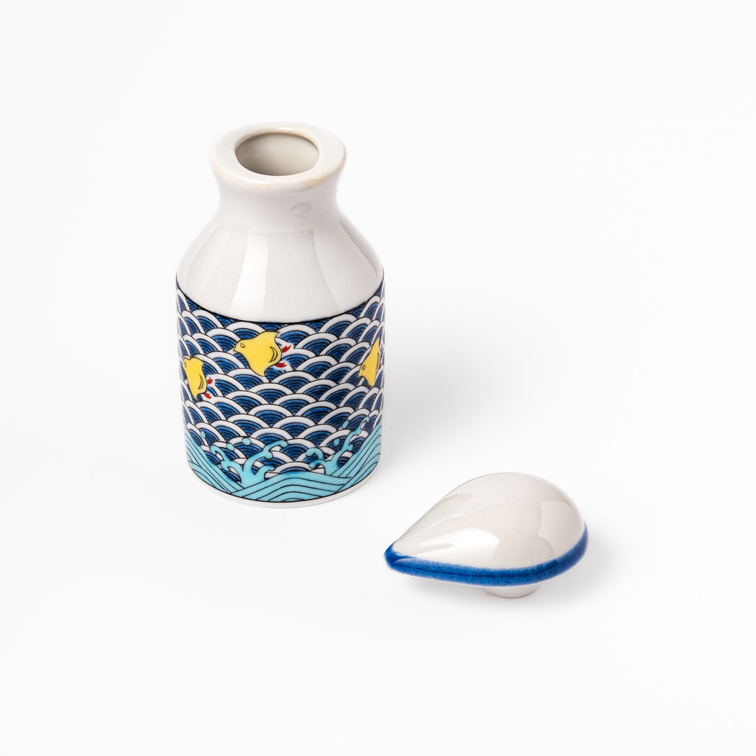 Japanese ceramic soy sauce dispenser featuring a blue wave pattern with yellow shorebirds, combining traditional design and playful detail for table use.