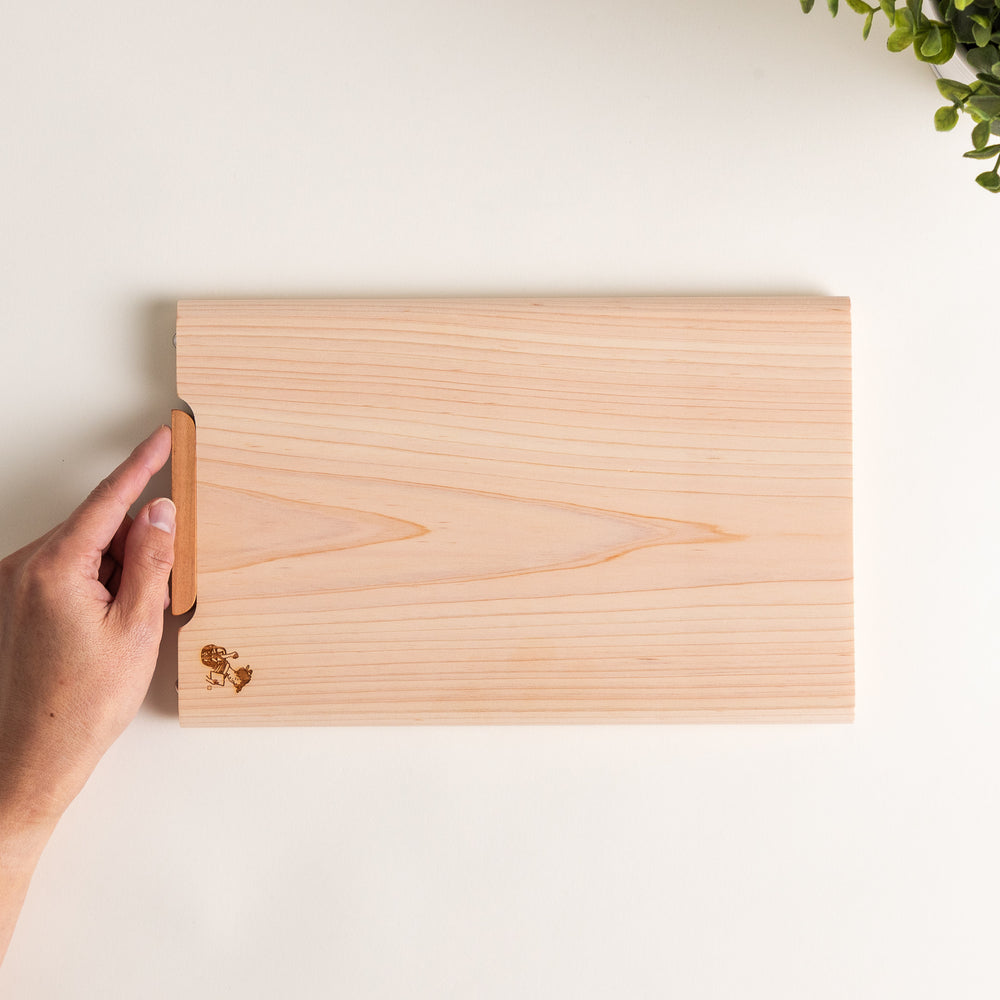 Small Hinoki wood cutting board with smooth grain, natural finish, corner handle, and engraved motif, crafted in Japan
