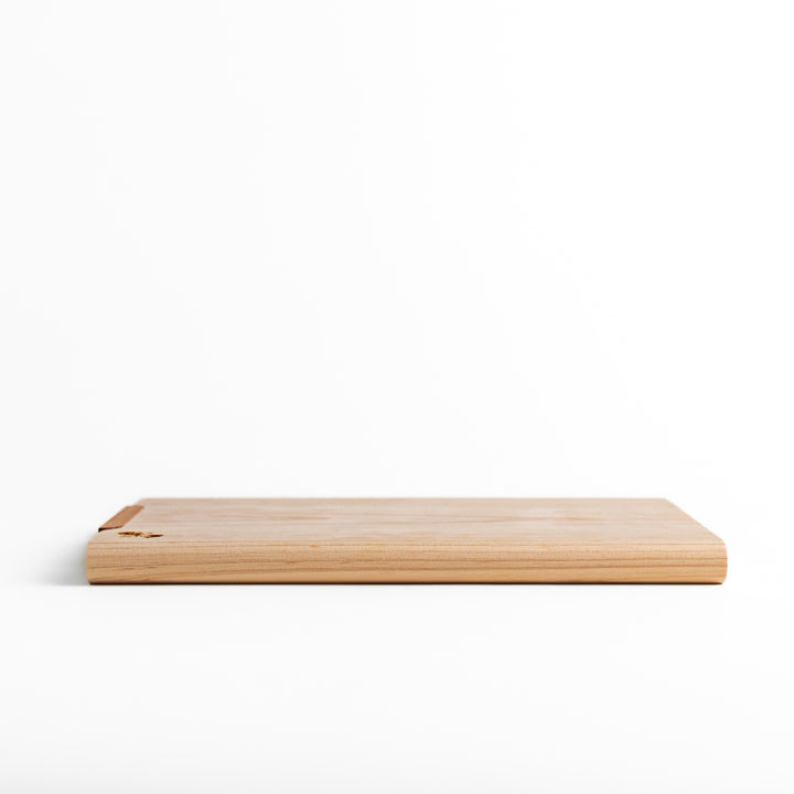 Small Hinoki wood cutting board with smooth grain, natural finish, corner handle, and engraved motif, crafted in Japan