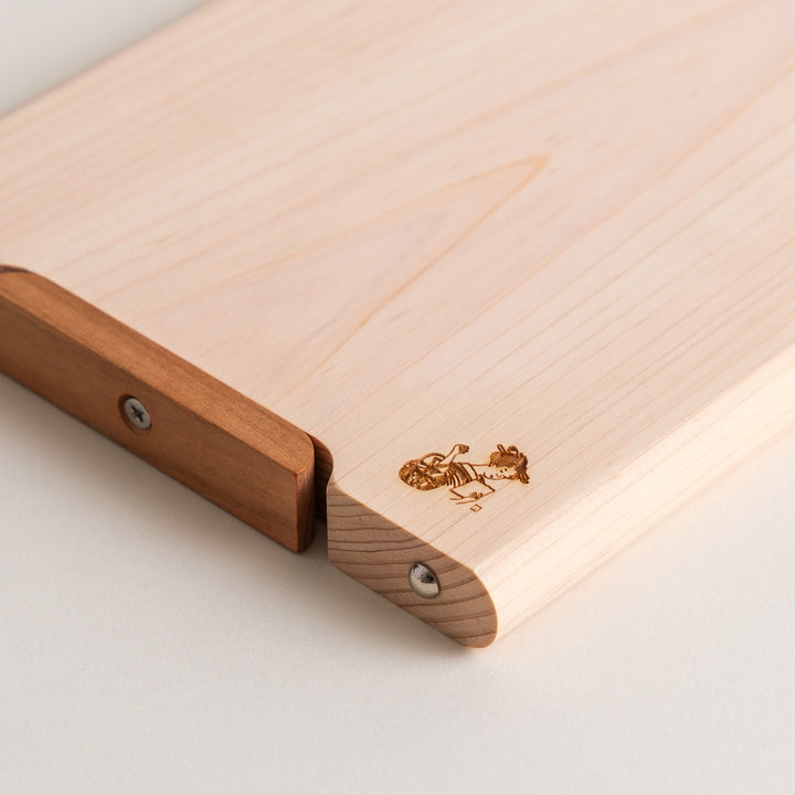 Small Hinoki wood cutting board with smooth grain, natural finish, corner handle, and engraved motif, crafted in Japan