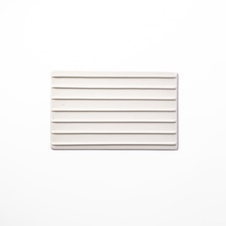 Textured white ceramic dinner plate with subtle ridged lines and matte-gloss contrast, perfect for refined Japanese dining and elegant plating.