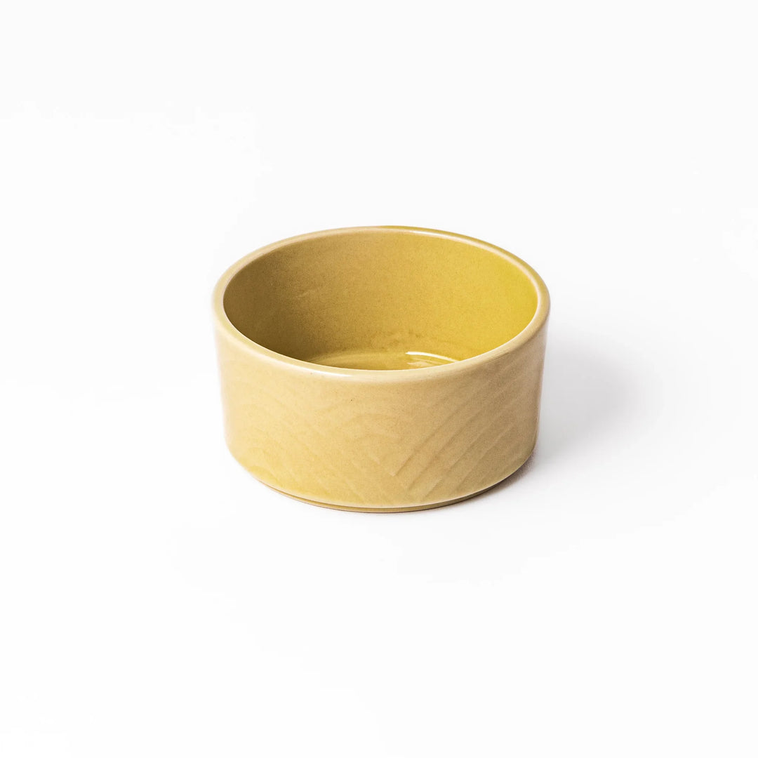 Yellow porcelain bowl with embossed Seigaiha wave pattern, showcasing a smooth matte glaze and simple, modern Japanese design.