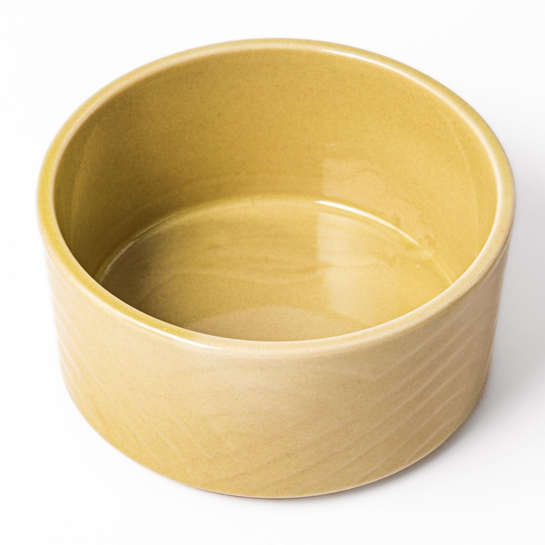 Yellow porcelain bowl with embossed Seigaiha wave pattern, showcasing a smooth matte glaze and simple, modern Japanese design.