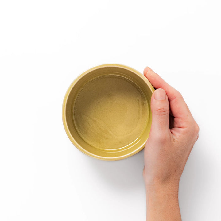 Yellow porcelain bowl with embossed Seigaiha wave pattern, showcasing a smooth matte glaze and simple, modern Japanese design.