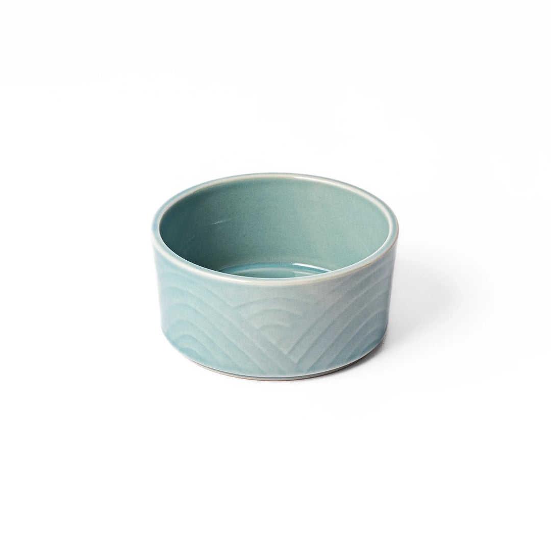 Light blue stackable porcelain bowl with embossed Seigaiha wave pattern, showcasing smooth matte texture and minimalist Japanese design.